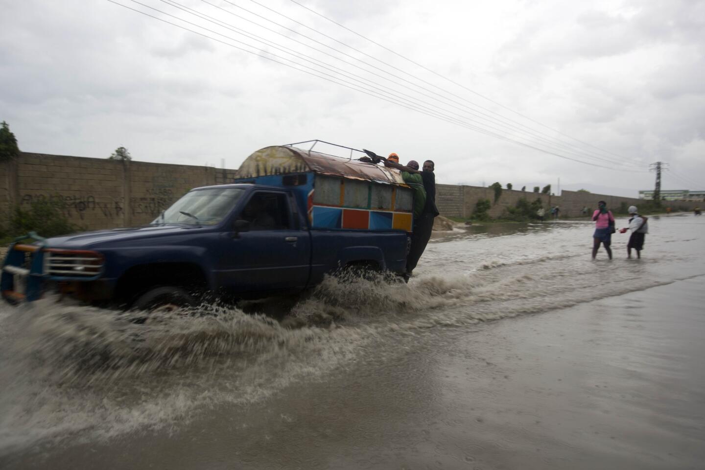 A "tap-tap" truck carrying commuters drives through a street flooded by rain brought by Hurricane Matthew in Port-au-Prince, Haiti, on Oct. 4, 2016.