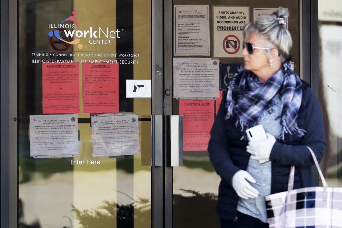 A woman looks to get information about a job application in front of an Illinois Department of Employment Security WorkNet center in Arlington Heights, Ill., last month. 