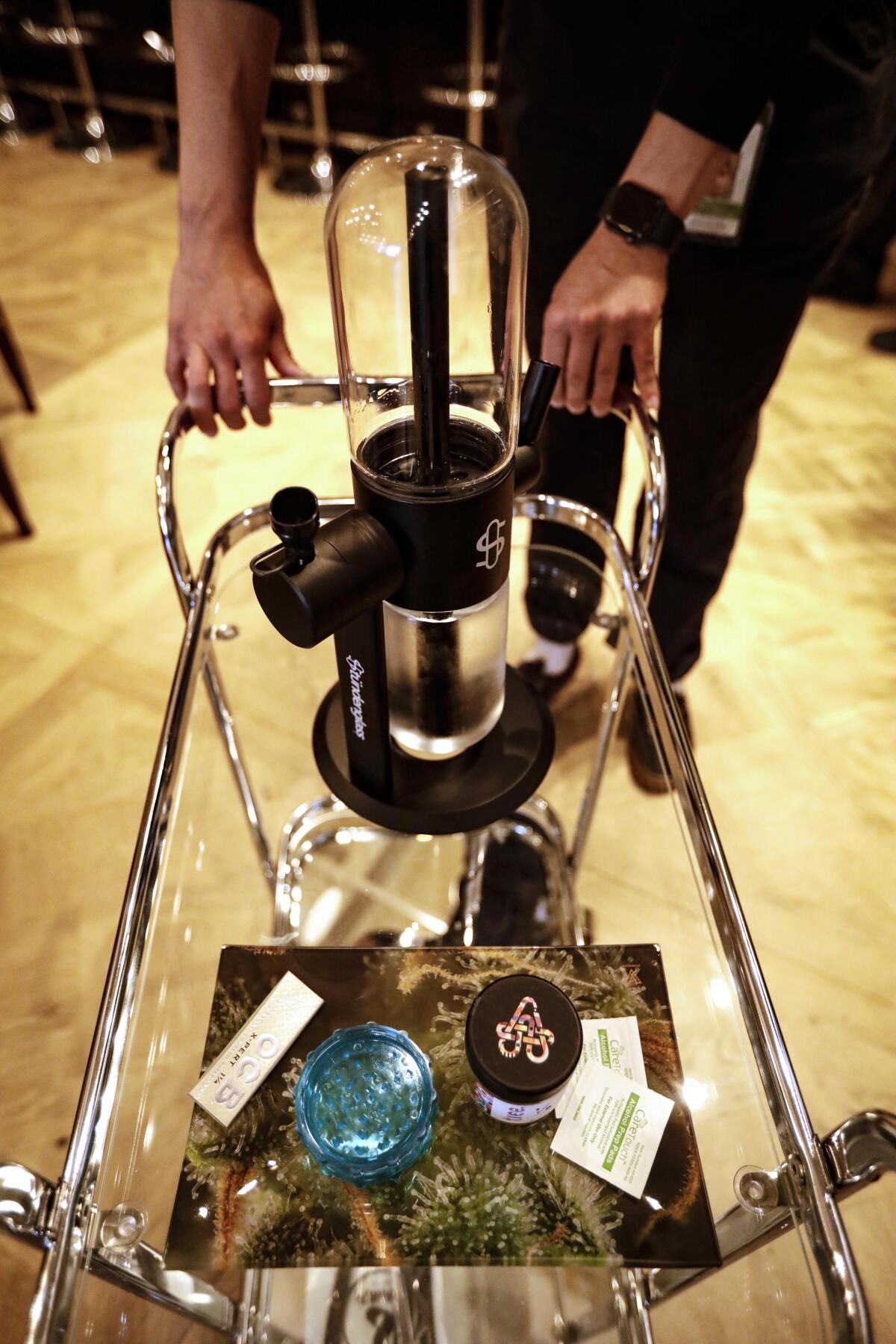 A bar cart stocked with a gravity bong and smoking accoutrements