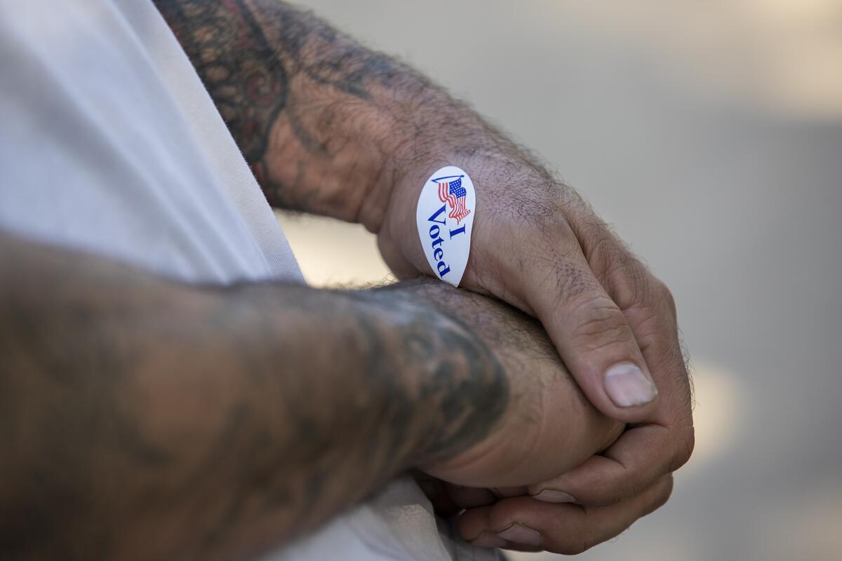 Felipe Garcia, 37, places his "I Voted" sticker on his hand after voting in his first election on Tuesday, November 3.