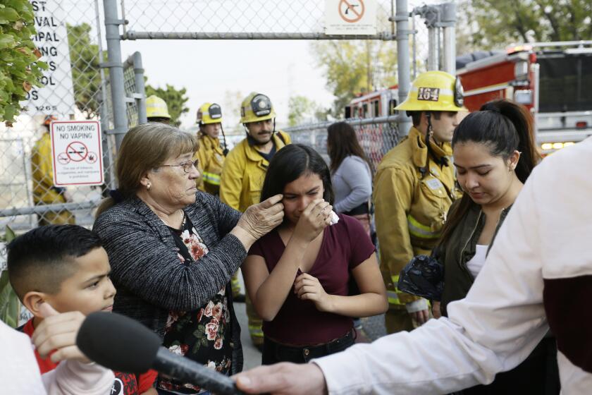 Student Marianna Torres, 11, center, cries as she evacuates Park Avenue Elementary School after jet fuel fell on the school in Cudahy, Calif., Tuesday, Jan. 14, 2020. Jet fuel dumped by an aircraft returning to Los Angeles International Airport fell onto the school playground where children were playing Tuesday, fire officials said. The Los Angeles County Fire Department said firefighters assessed over a dozen children and several adults who complained of minor injuries and none needed to be taken to a hospital. (AP Photo/Damian Dovarganes)