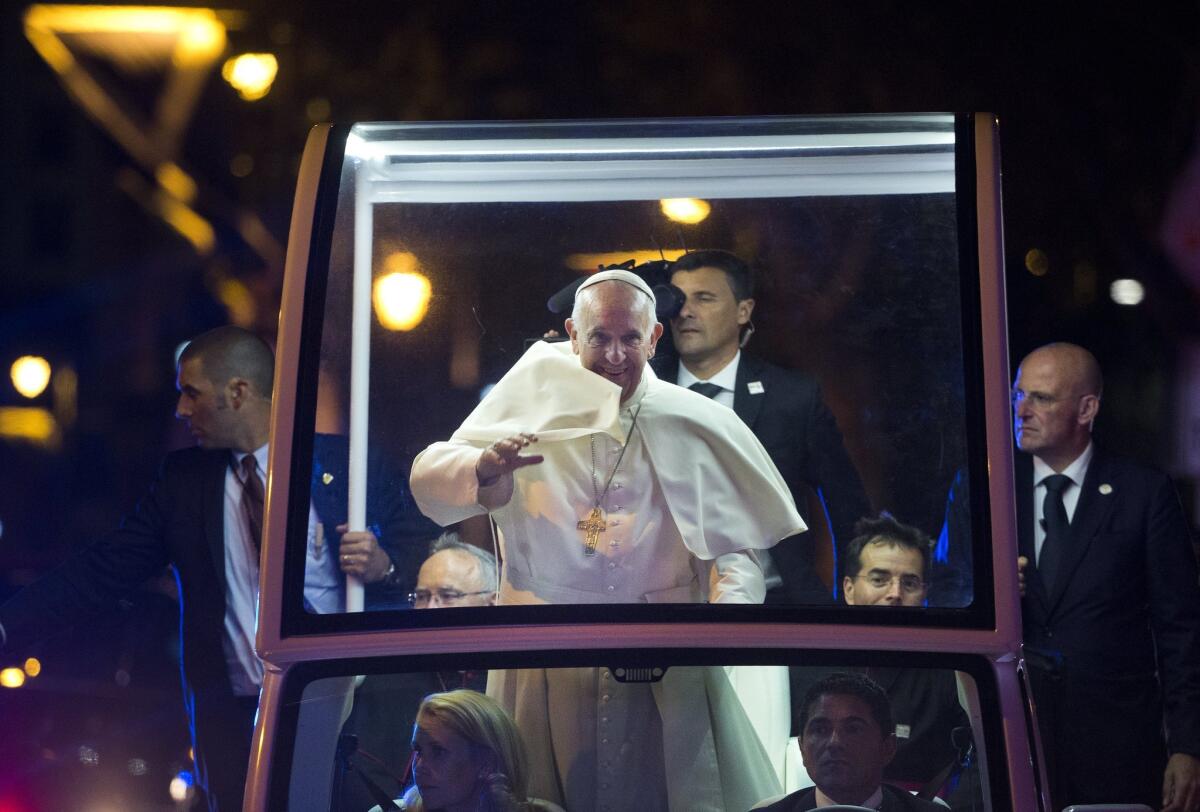 Pope Francis waves to the crowd from the popemobile during a parade in Philadelphia.