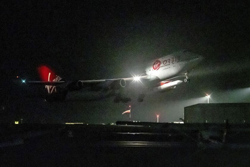 FILE - A repurposed Virgin Atlantic Boeing 747 aircraft, named Cosmic Girl, carrying Virgin Orbit's LauncherOne rocket, takes off from Spaceport Cornwall at Cornwall Airport, Newquay, England, on Jan. 9, 2023. Virgin Orbit said Thursday March 16, 2023 it is pausing all operations amid reports that the company is furloughing almost all its staff as part of a bid to seek a funding lifeline. (Ben Birchall/PA via AP)