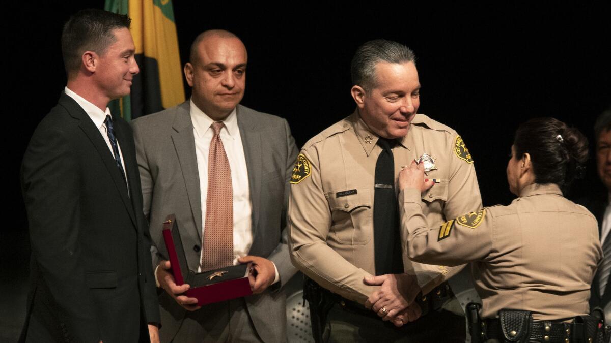 Caren Carl Mandoyan, second from left, was fired from the L.A. County Sheriff's Department after being accused of domestic abuse and stalking. He was rehired by Sheriff Alex Villanueva after working on Villanueva's campaign.