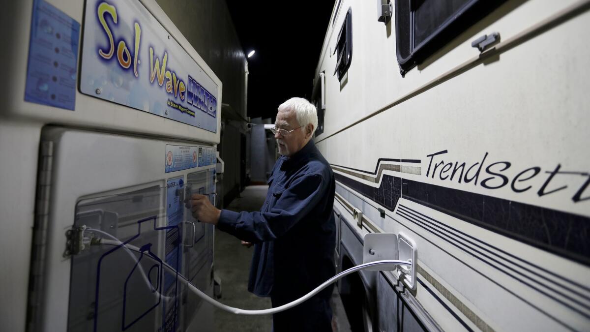 It's nearly midnight and Phil, 74, is outside his RV paying for filtered water with quarters from the vehicle.