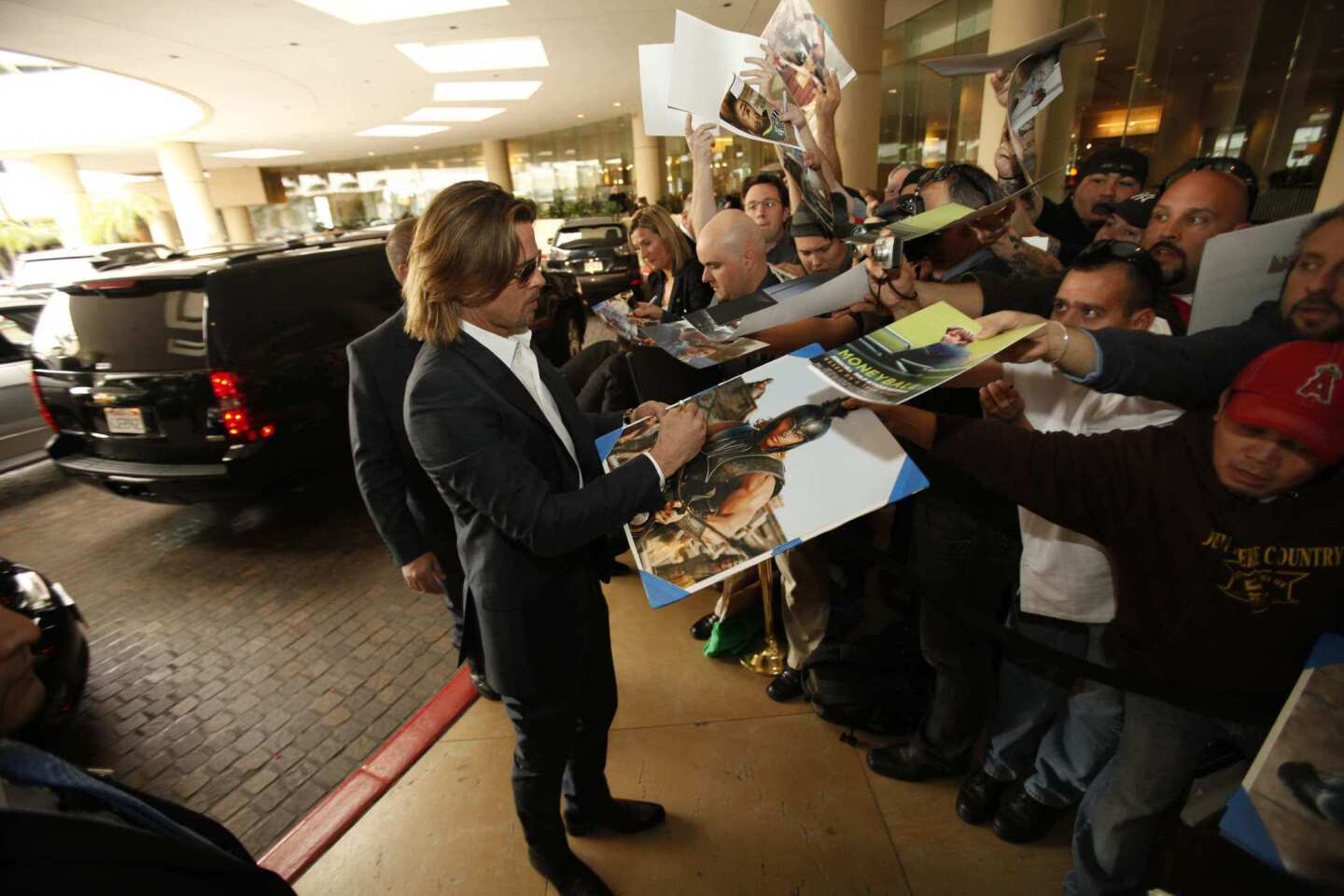 "Moneyball" and "The Tree of Life" nominee Brad Pitt signs autographs outside the Beverly Hilton Hotel.