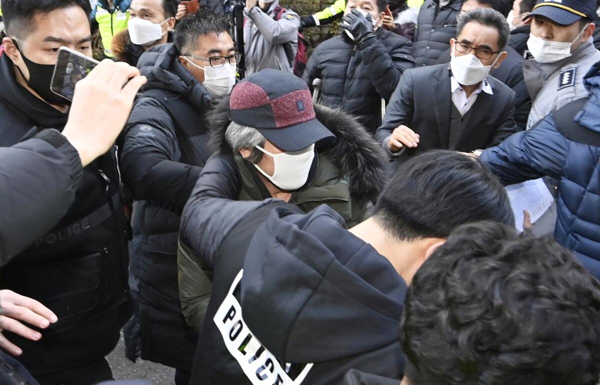 Child rapist Cho Doo-soon, escorted by police officers, arrives home in Ansan, South Korea.