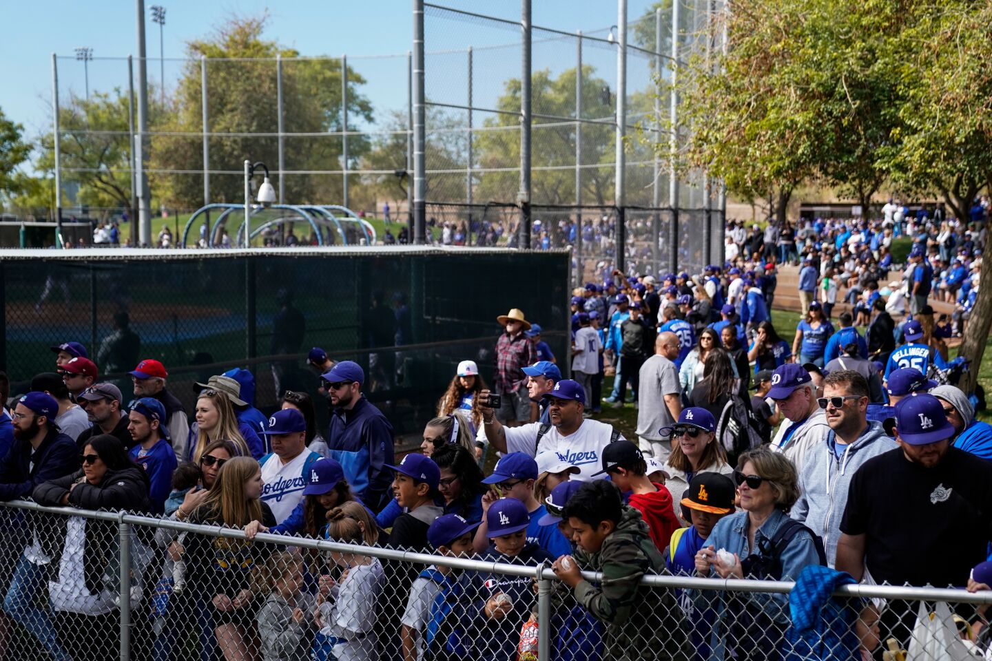 Fans try to catch a glimpse of the Dodgers during batting practice at Camelback Ranch before an exhibition game against the Chicago Cubs on Feb. 23, 2020.