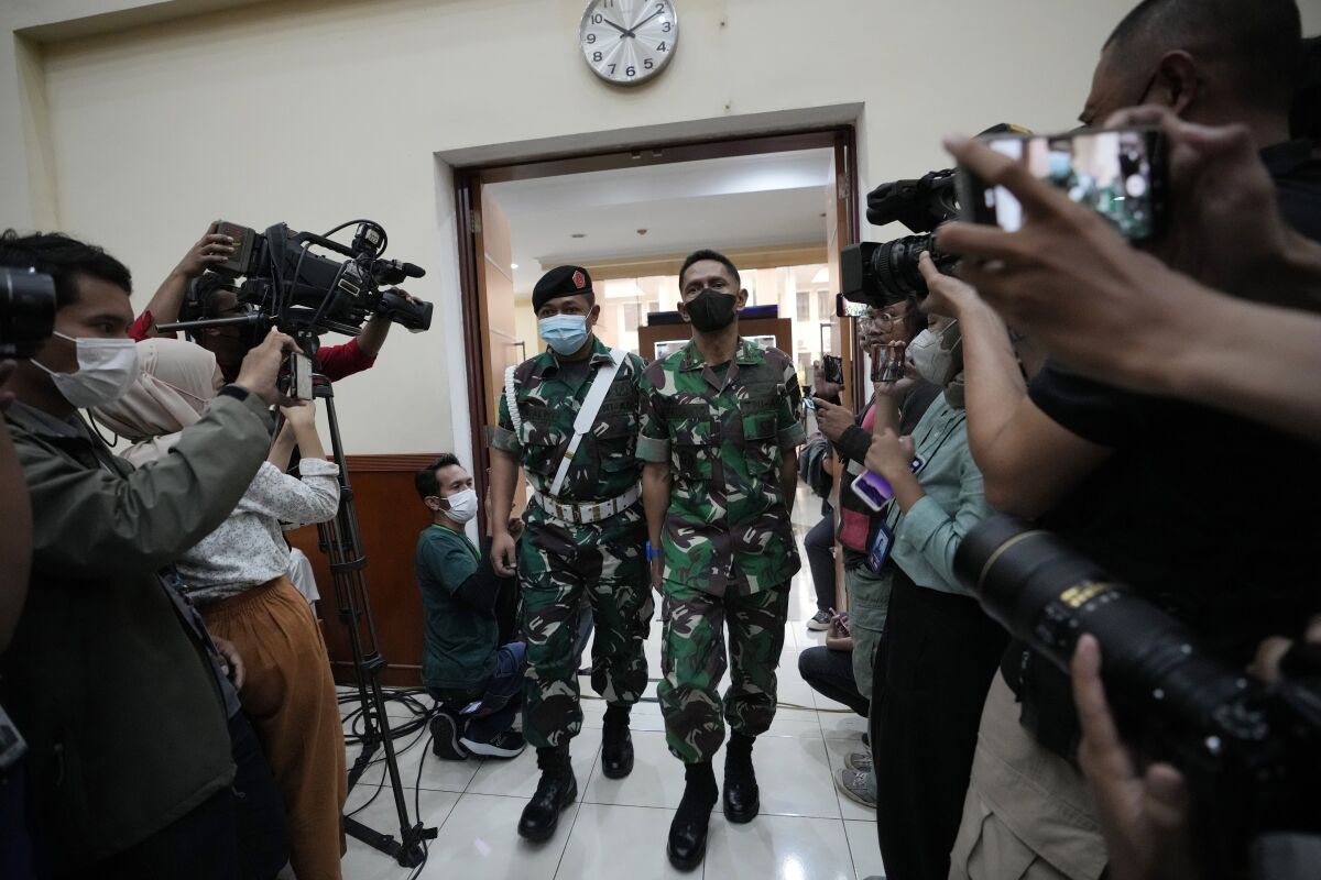 Colonel Priyanto, a mid rank army officer, center, walks in a courtroom before his trial at the local military court in Jakarta, Indonesia, Tuesday, June 7, 2022. Col. Priyanto is being stripped of his military title after he was sentenced Tuesday to life in prison for murder, joint deprivation of the independence of others and removing the bodies with the intention of concealment. (AP Photo/Achmad Ibrahim)