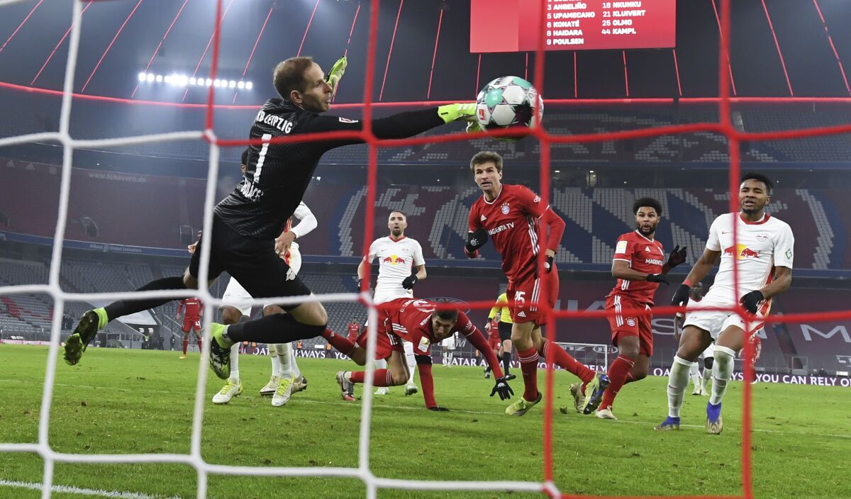 Munich's Thomas Mueller scores the goal for the 3:3 against Leipzig's goalkeeper Peter Gulacsi during the Bundesliga soccer match between Bayern Munich and RB Leipzig in Munich, Germany, Saturday, Dec. 5, 2020. (Sven Hoppe/Pool via AP)