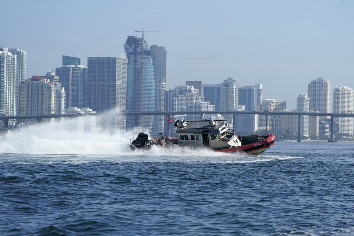 A U.S. Coast Guard boat with Miami coastal high rise building in the background 