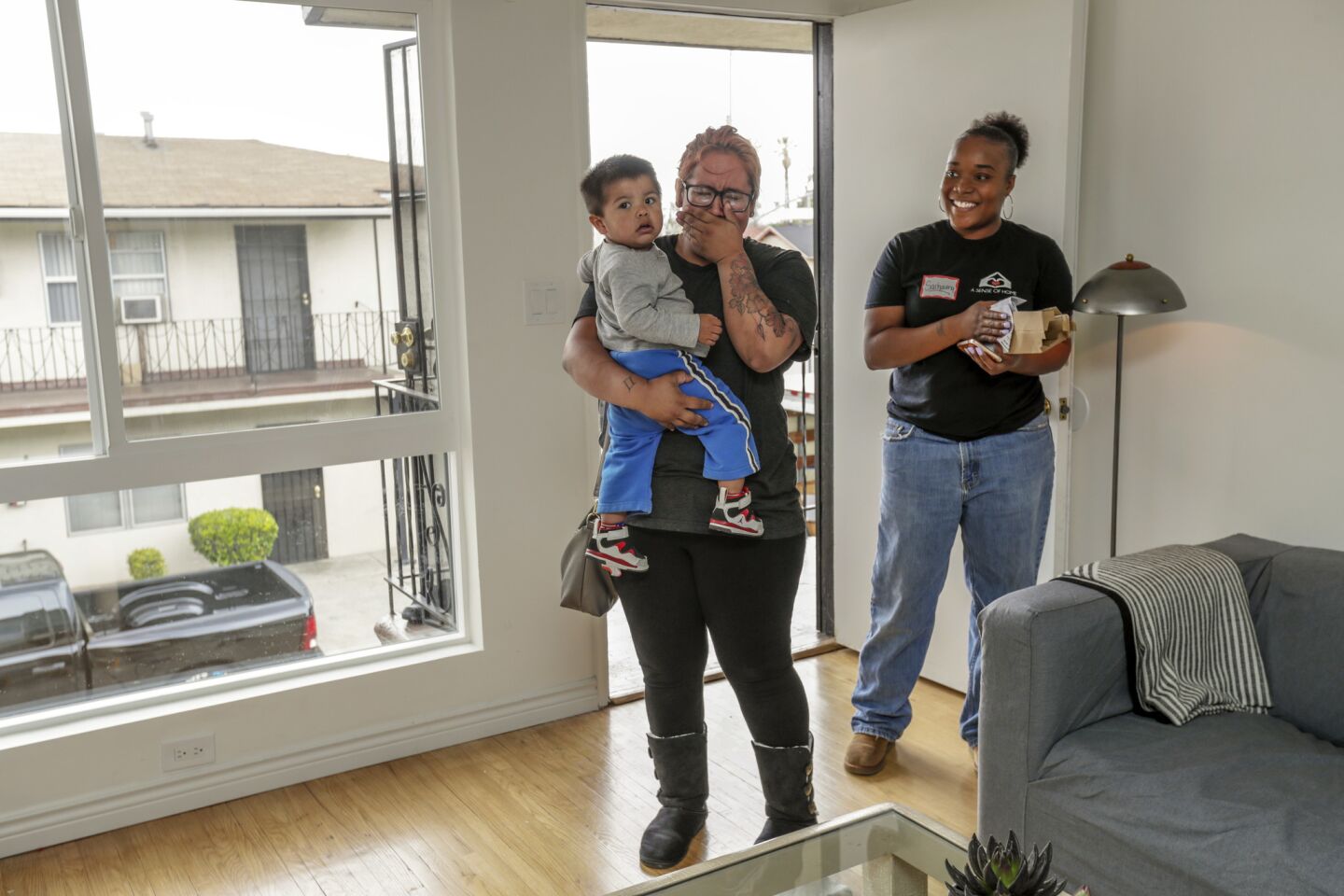 Elana Frey, holding her young son, Kalani, weeps as she enters her newly furnished apartment a day before Mother's Day in Los Angeles. Frey was assisted by A Sense of Home, an L.A. charity that helps at-risk former foster youth who age out of the system.