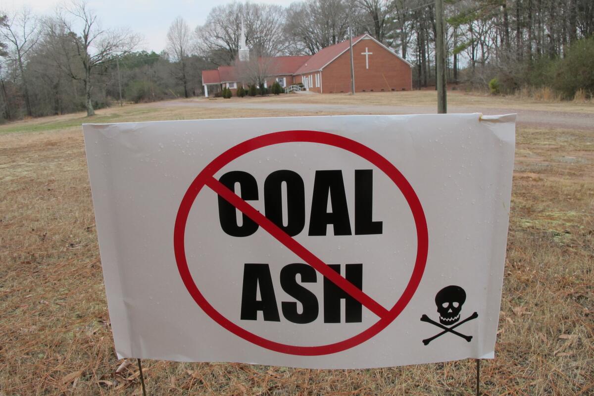 A sign at Mount Calvary Baptist Church in Lee County, N.C., protests a plan by Duke Energy to fill a clay mine pit near the church with eight tons of coal ash from Duke plants more than 100 miles away.