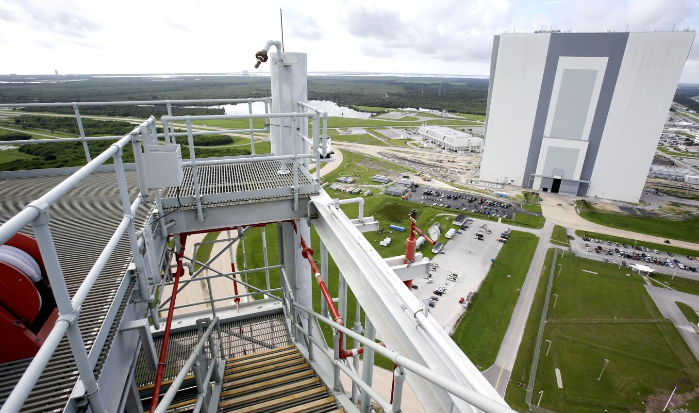 A view of the Vehicle Assembly Building, right, is seen from atop the over 400 foot high mobile launcher structure that will support NASA's Space Launch System (SLS) at the Kennedy Space Center is seen, Wednesday, Aug. 19, 2015, in Cape Canaveral, Fla. SLS is the agency’s new rocket that will launch astronauts in the Orion spacecraft on missions to an asteroid and eventually to Mars. (AP Photo/John Raoux) ORG XMIT: KSC103