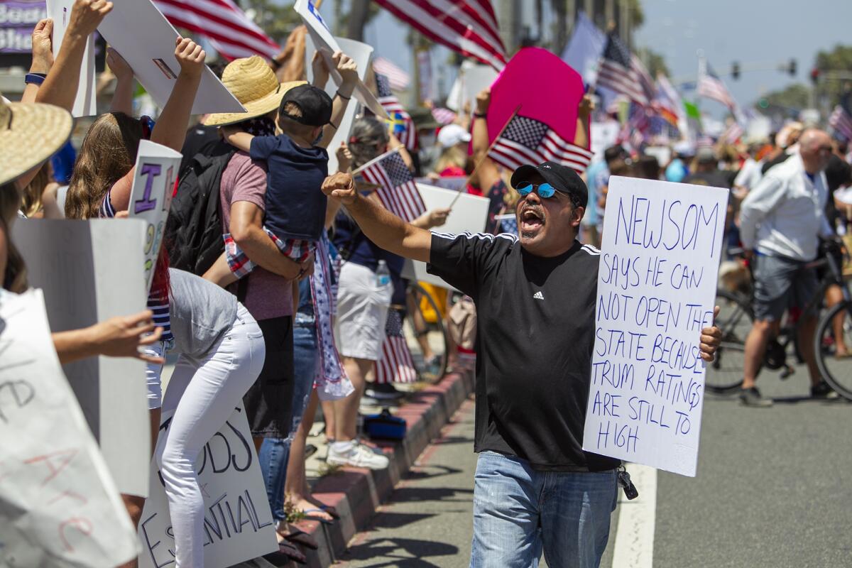 A protester rallies the crowd during a protest of Gov. Gavin Newsom's stay-at-home orders in Huntington Beach on Friday.
