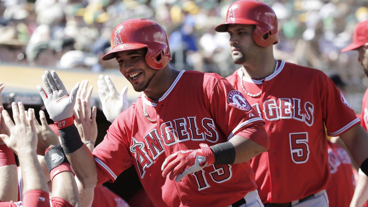 The Angels' Luis Jimenez, center, celebrates after scoring on a sacrifice fly against the Oakland Athletics on Sept. 24.