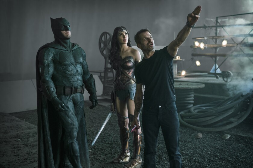 Ben Affleck as Batman standing with Gal Gadot as Wonder Woman while Zack Snyder directs