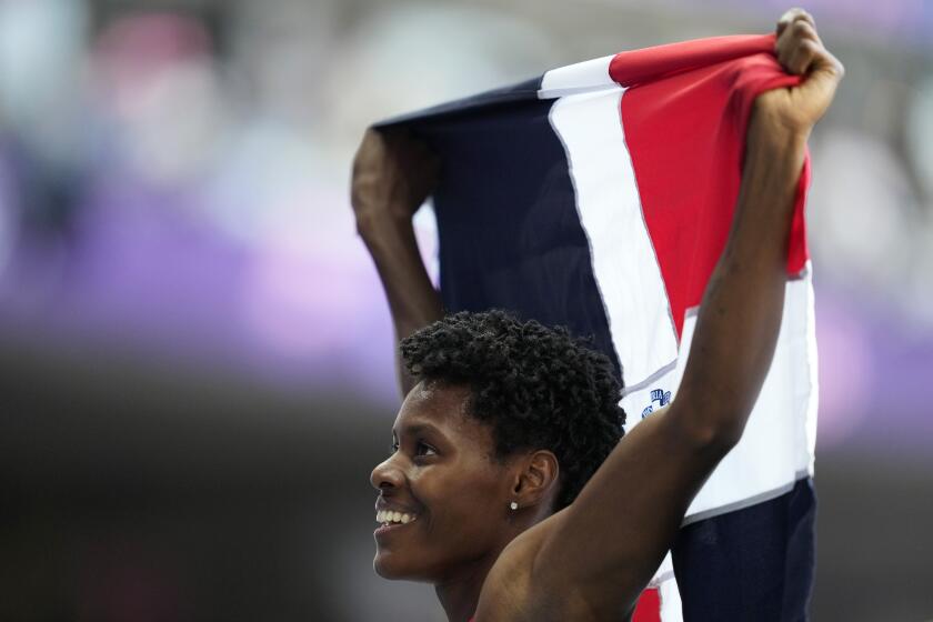 La dominicana Marileidy Paulino celebra tras ganar los 400 metros del atletismo de los Juegos Olímpicos de París, el viernes 9 de agosto de 2024, en Saint-Denis, Francia. (AP Foto/Ashley Landis)