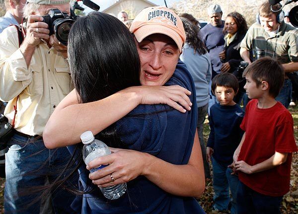 Kimberly Hicks, facing camera, hugs Mayumi Heene, the mother of 6-year-old Falcon Heene, after the boy was safely found in the family garage.