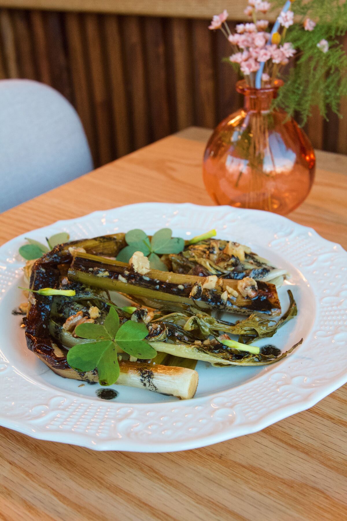 Braised leeks and endives with walnuts in vinaigrette on a white plate