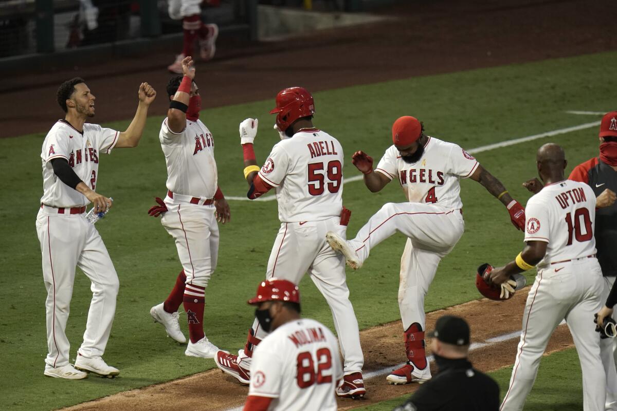 The Angels' Jo Adell and teammates celebrate his seventh-inning, walk-off single against the Astros.