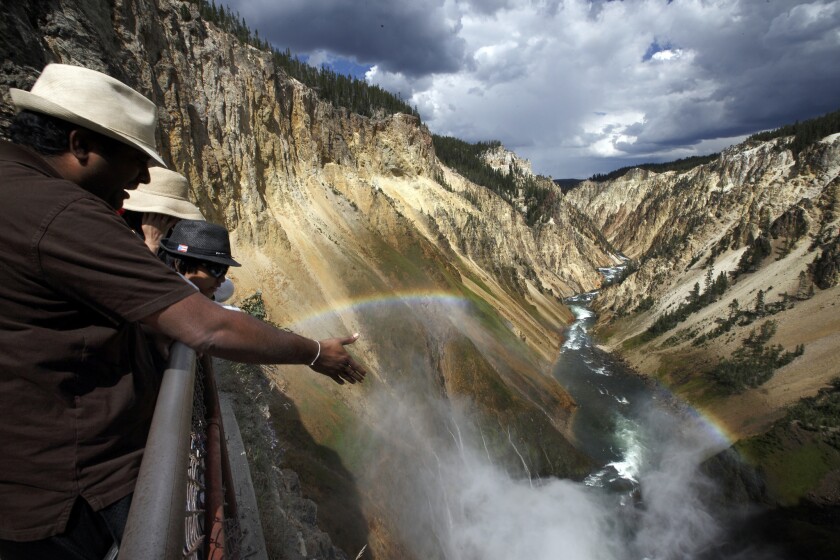 Visitors view the Yellowstone River from an observation deck in the Grand Canyon of Yellowstone National Park