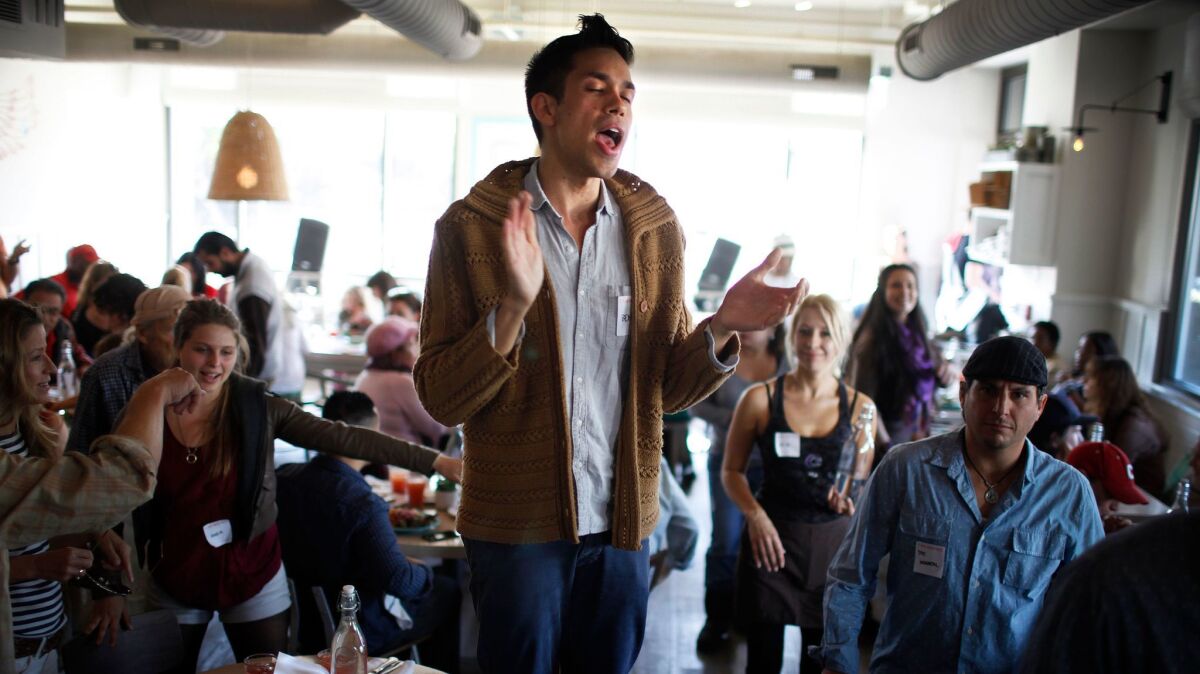 Patrons sing together at a vegan Thanksgiving meal at Cafe Gratitude in Venice.
