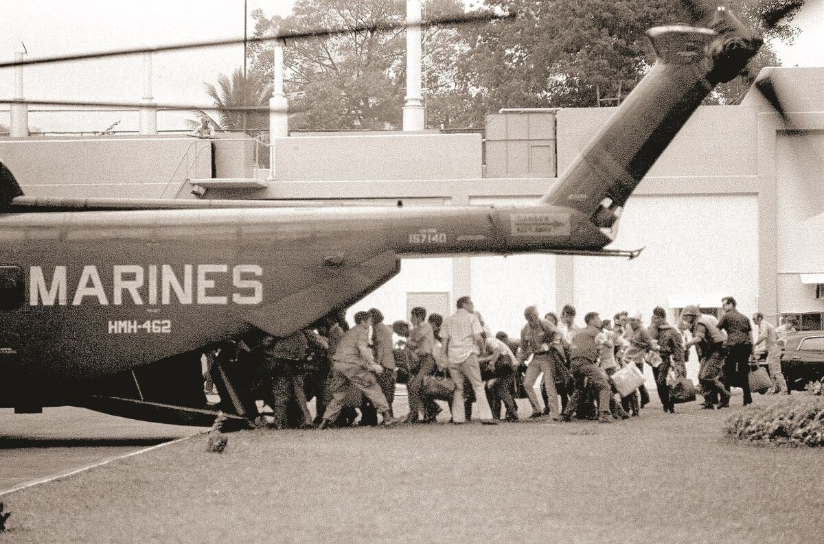 U.S. military and civilian personnel rush to board a Marine helicopter during the evacuation of the U.S. Embassy in Saigon, April 29, 1975.