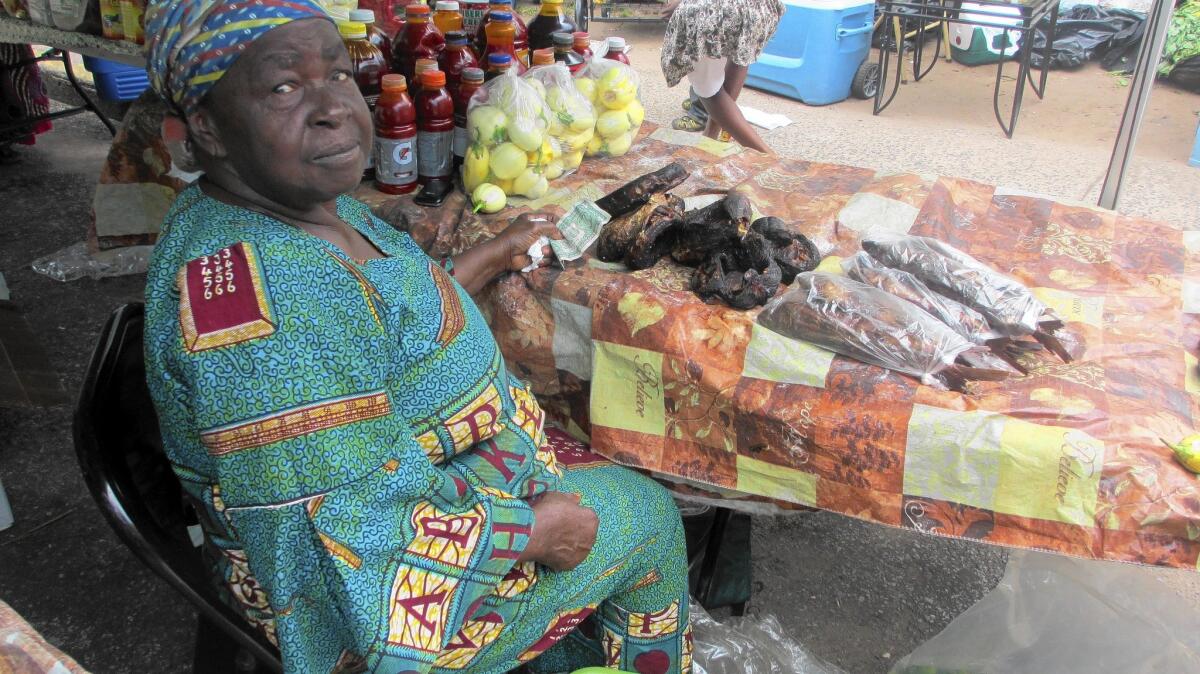 Atta Caflee, a Liberian living in Staten Island, N.Y., sells dried fish at an outdoor market in the Little Liberia neighborhood. Residents are feeling the effects of the Ebola outbreak in West Africa.