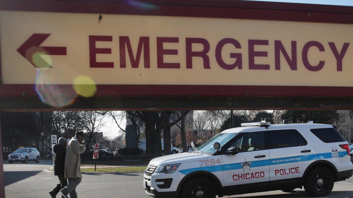 A police vehicle on Tuesday sits outside Mercy Hospital in Chicago, where four people were shot and killed the day before.