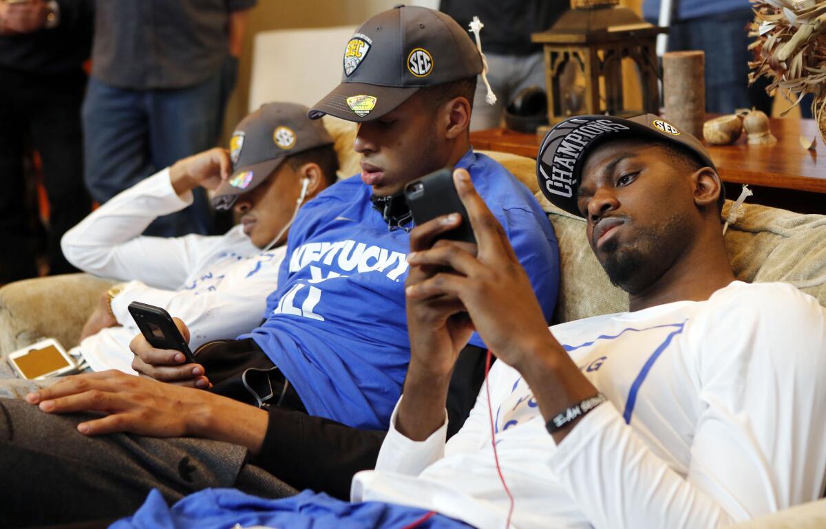 Kentucky's Tyler Ulis, left, sleeps while Skal Labissiere and Alex Poythress check their phones as other members of the men's basketball team watch the NCAA tournament selection show at the home of Coach John Calipari on Sunday.