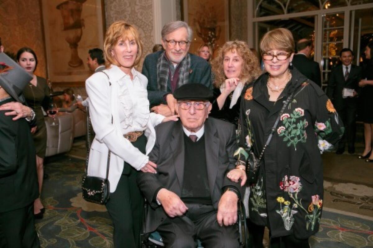 Arnold Spielberg sits in a wheelchair while posing for a photo with his family