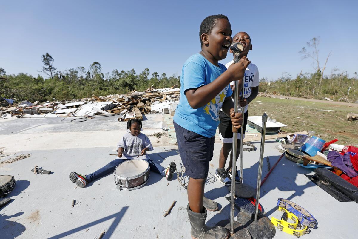 Children play in a neighborhood in Prentiss, Miss., damaged by a tornado April 12.