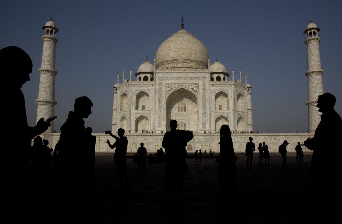 FILE - In this Sunday, March 24, 2019, file photo, tourists visit the Taj Mahal monument, in Agra, India. India reopened to fully vaccinated foreign tourists traveling on chartered flights on Friday, Oct. 15, 2021, in the latest easing of its coronavirus restrictions as infection numbers decline. Foreign tourists on regular flights will be able to enter India starting Nov. 15. (AP Photo/Manish Swarup)