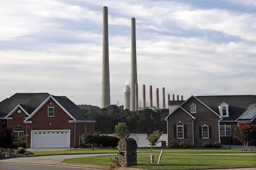 FILE - In this Aug. 7, 2019, file photo, the Kingston Fossil Plant smokestacks rise above the trees behind homes in Kingston, Tenn. The nation's largest public utility is looking at shutting down three of its five remaining coal-fired power plants, saying they are old and no longer practical. At a public hearing this week on the proposed closure of the Kingston Fossil Plant, TVA Senior Manager of Enterprise Planning Jane Elliott stressed the fact that gas provides reliability and flexibility as a fuel that can be called upon at any hour of any day. (AP Photo/Mark Humphrey, File)