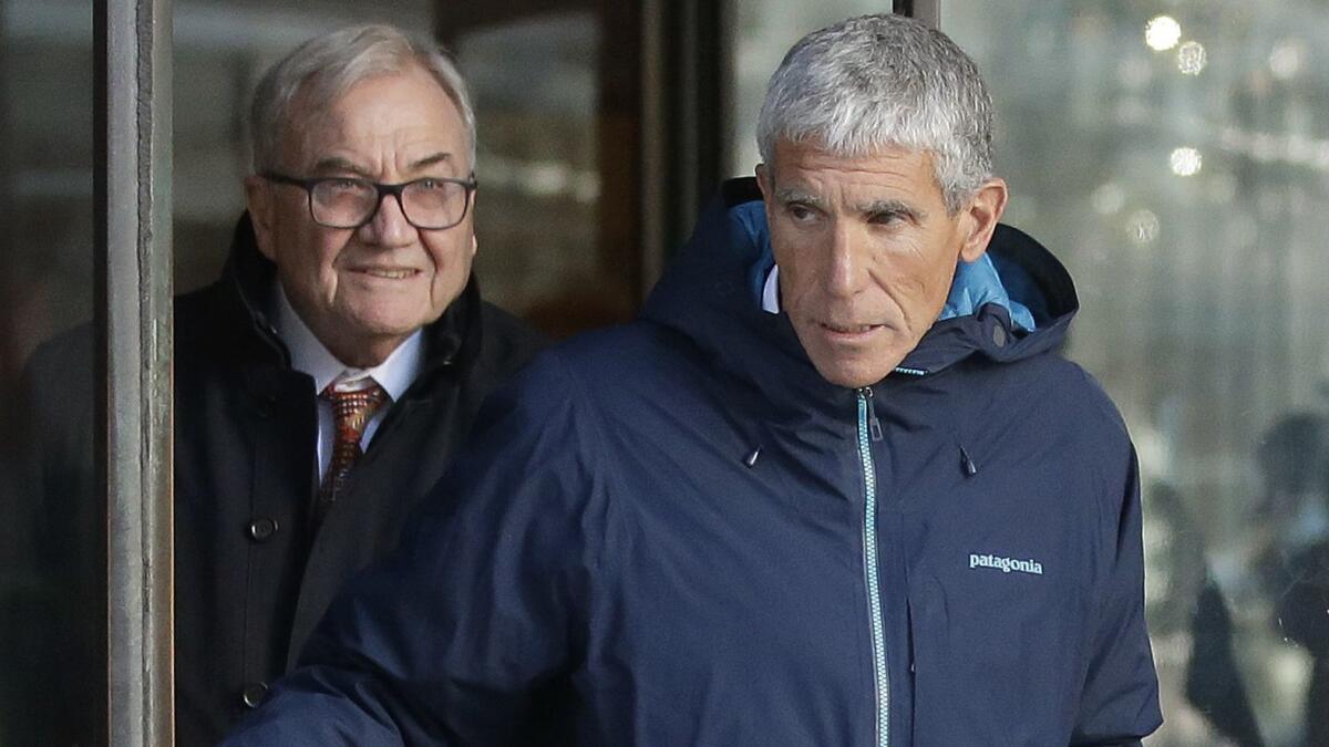 William “Rick” Singer, front, founder of the Edge College & Career Network, exits federal court in Boston on Tuesday after he pleaded guilty to charges in a nationwide college admissions bribery scandal.