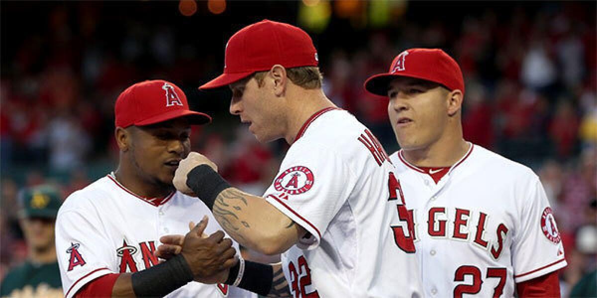Erick Aybar, Josh Hamilton and Mike Trout greet one another prior to the start of the Angels' home opener against the Oakland Athletics.