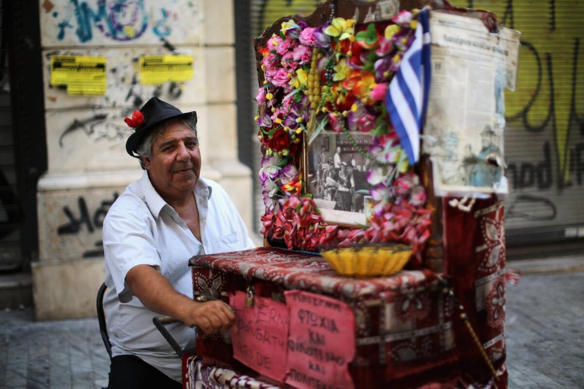 An organ grinder plays his antique machine for passing shoppers on Thursday in Athens. The Greek government has hours left to offer Eurozone creditors a viable plan to recovery.