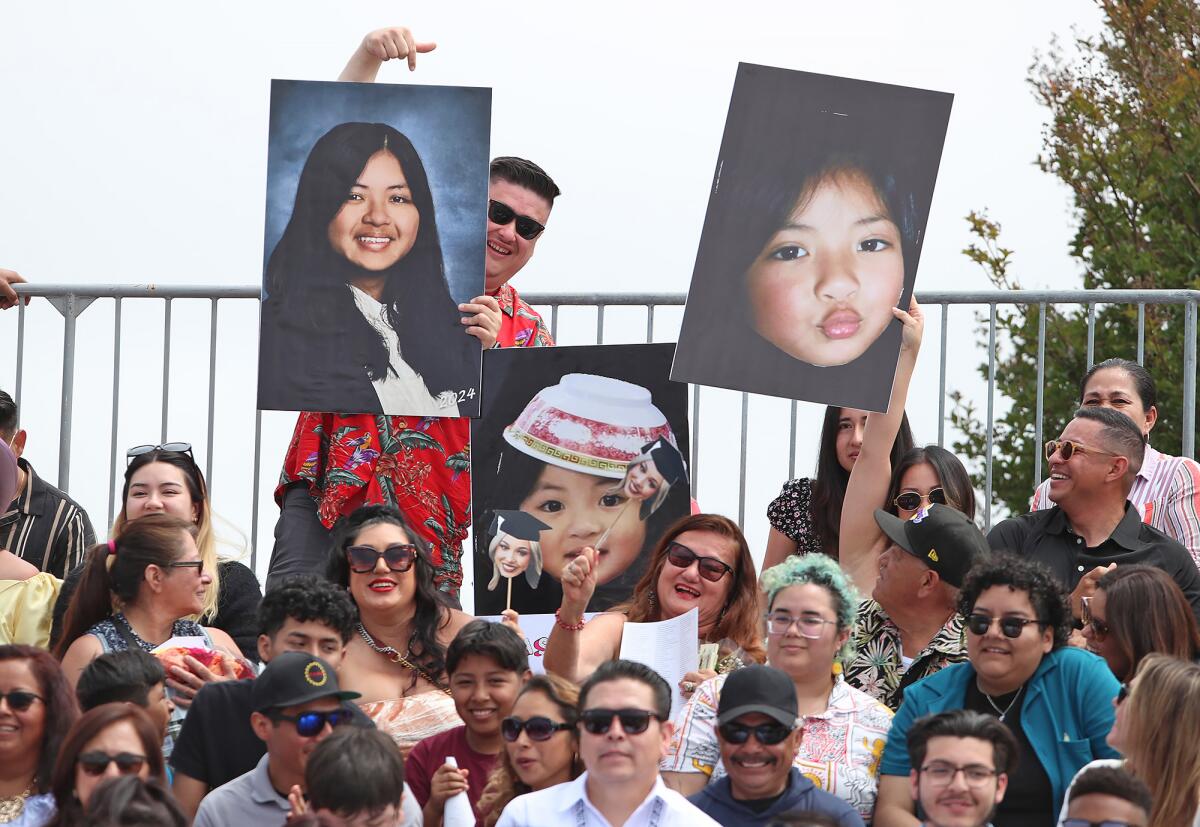 Parents hold up giant grad pictures and scream names during Costa Mesa High School's commencement.