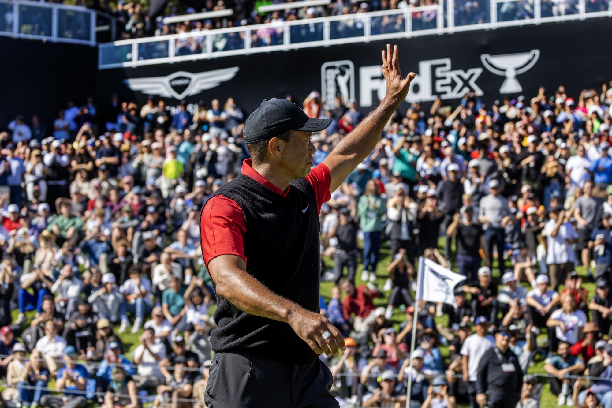 Tiger Woods waves goodbye to the crowd after finishing his final round at Riviera Country Club on Sunday.