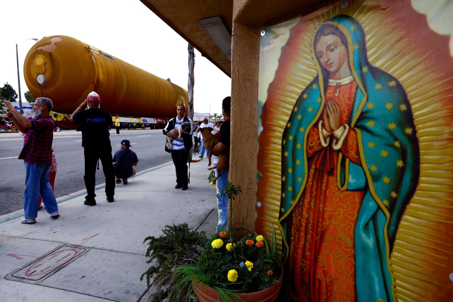 The space shuttle fuel tank moves past a mural of the Virgin of Guadalupe on La Brea Avenue in Inglewood.