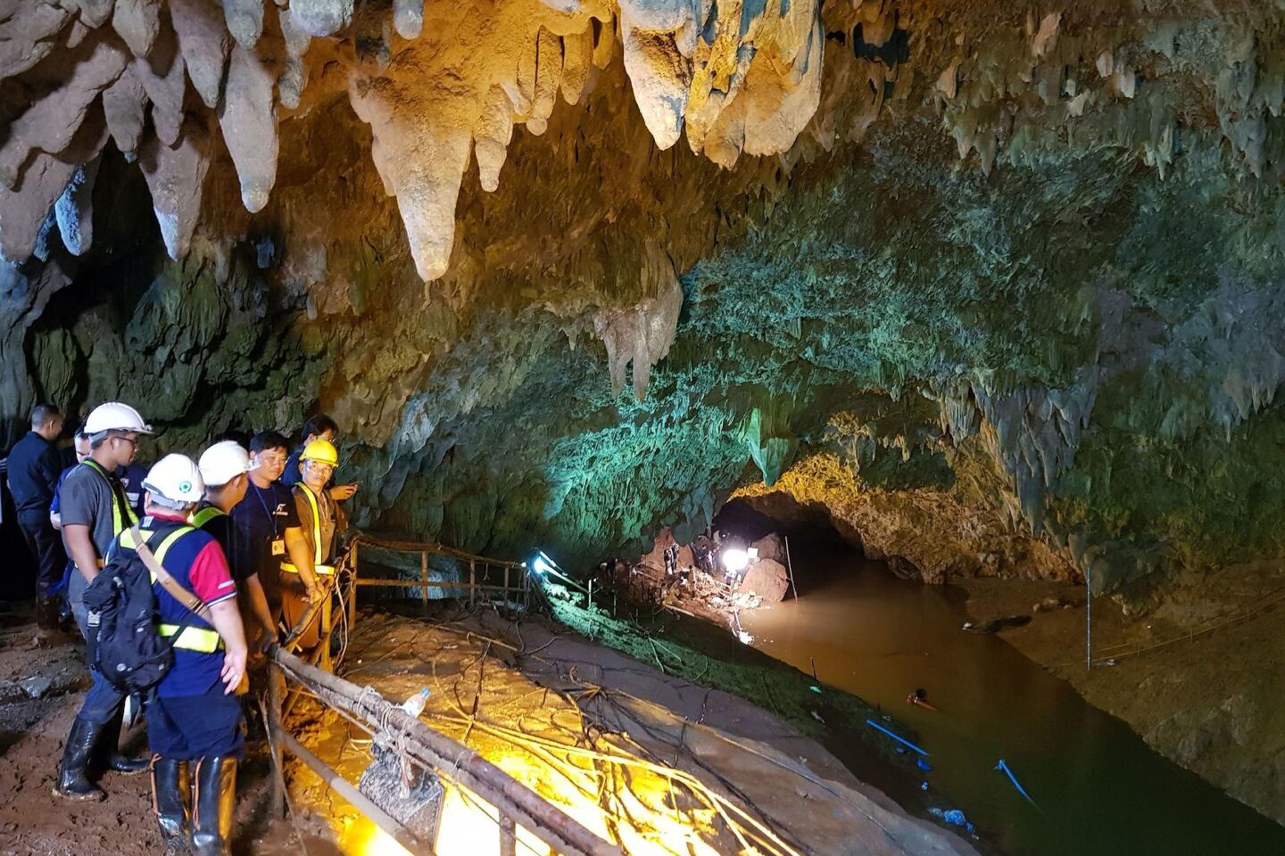Thai workers attempt to drain the water from the cave during the search and rescue operation.