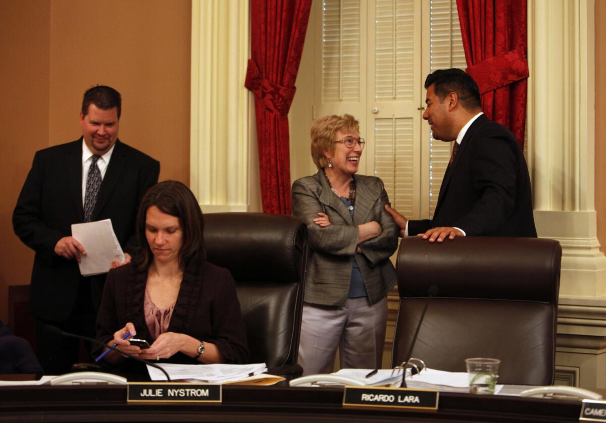 State Sen. Jean Fuller (R-Bakersfield) speaks with Sen. Ricardo Lara (D-Bell Gardens) during a break in a Rules Committee meeting at the Capitol on March 20, 2013.