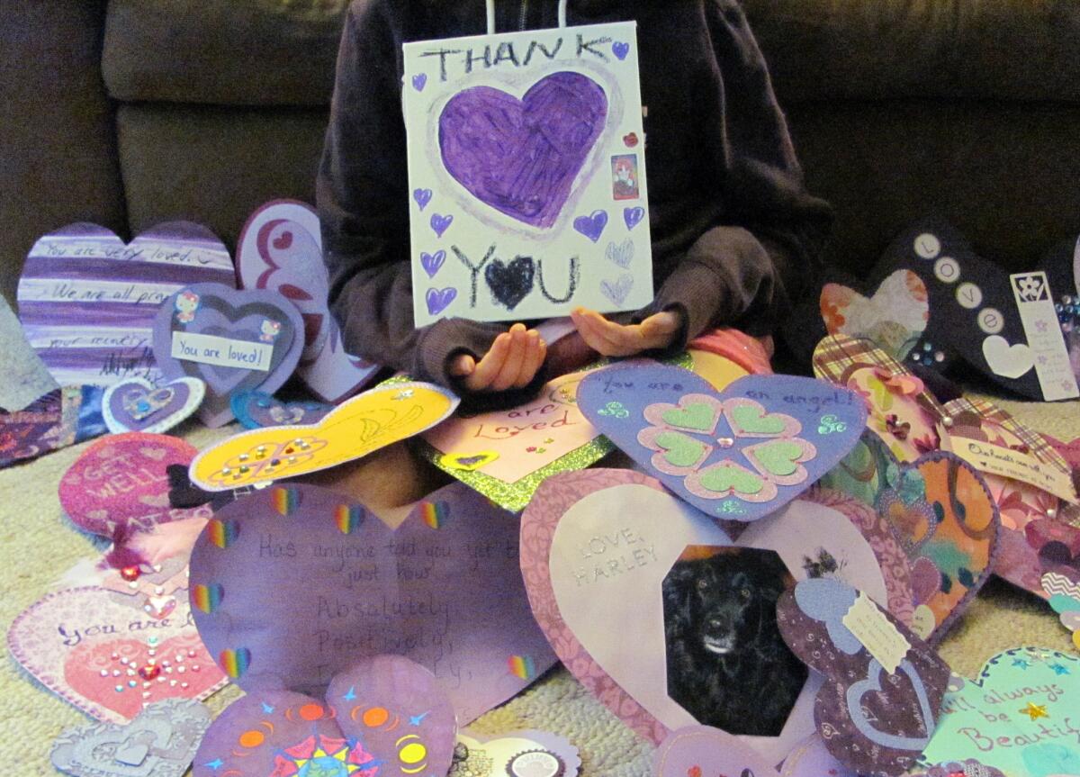 A 12-year-old Waukesha, Wis., girl who wished to remain unidentified, holds a "Thank You" poster for the many supporters from around the world that have sent her cards. The girl was stabbed 19 times in the legs, arms and torso last month.