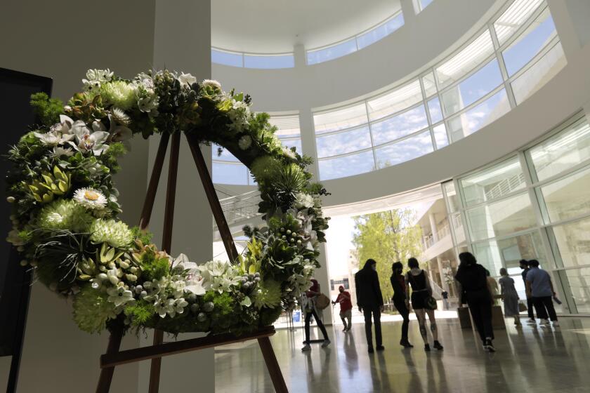 LOS ANGELES, CA - MAY 25, 2021 - - A wreath in honor of those who lost their lives to COVID-19 rests in the Rotunda while visitors return to The Getty Center for the first time in over a year in Los Angeles on May 25, 2021. The Getty Center, which has been shutdown since March 2020 due to the coronavirus pandemic, reopened to visitors. A thousand tickets were made available to visitors and were all sold out. The tickets were free since The Getty Center does not charge to visit the museum. The Getty Center had specific one-way routes and other measures in place to ensure the safety of visitors and staff. Masks were required for the entire visit. (Genaro Molina / Los Angeles Times)