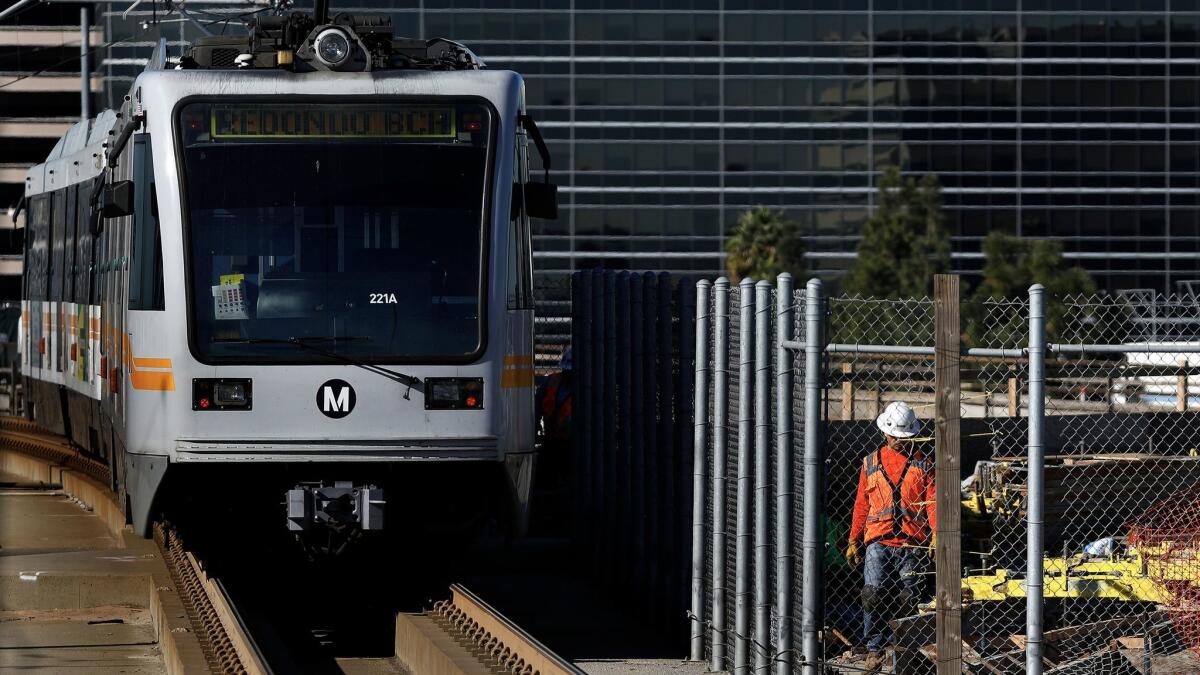 A Green Line train leaves the Aviation/LAX station as work is underway for the future Crenshaw/LAX line.