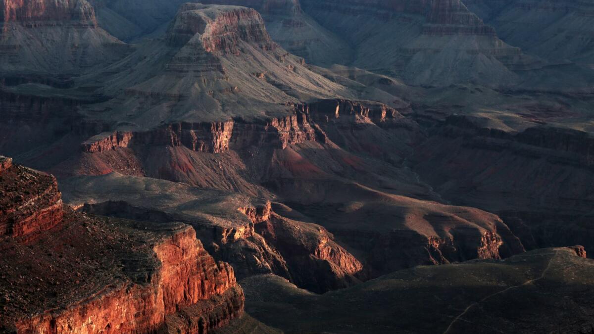 The sun begins to rise at Mather Point on the South Rim of the Grand Canyon. The national park there will not close during the partial federal government shutdown, Arizona's governor said.