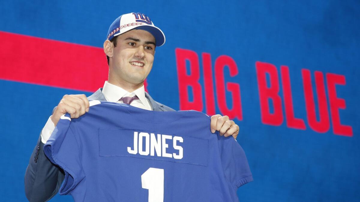 Duke quarterback Daniel Jones poses with a New York Giants jersey after being selected sixth overall in the NFL draft.