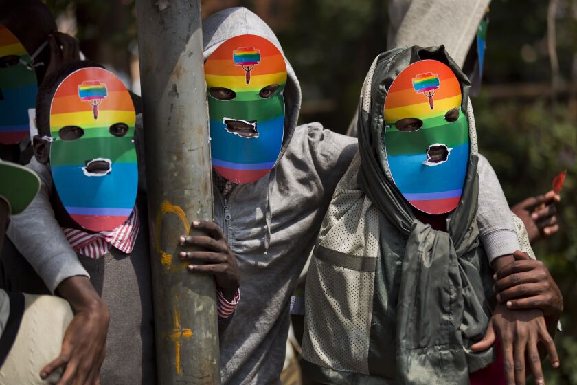FILE - Kenyan gays and lesbians and others supporting their cause wear masks to preserve their anonymity as they stage a rare protest against Uganda's tough stance against homosexuality and in solidarity with their counterparts there, outside the Uganda High Commission in Nairobi, Kenya on Feb. 10, 2014. Ugandan lawmakers passed a bill Tuesday, March 21, 2023 prescribing jail terms of up to 10 years for offenses related to same-sex relations, responding to popular sentiment but piling more pressure on the East African country's LGBTQ community. (AP Photo/Ben Curtis, File)