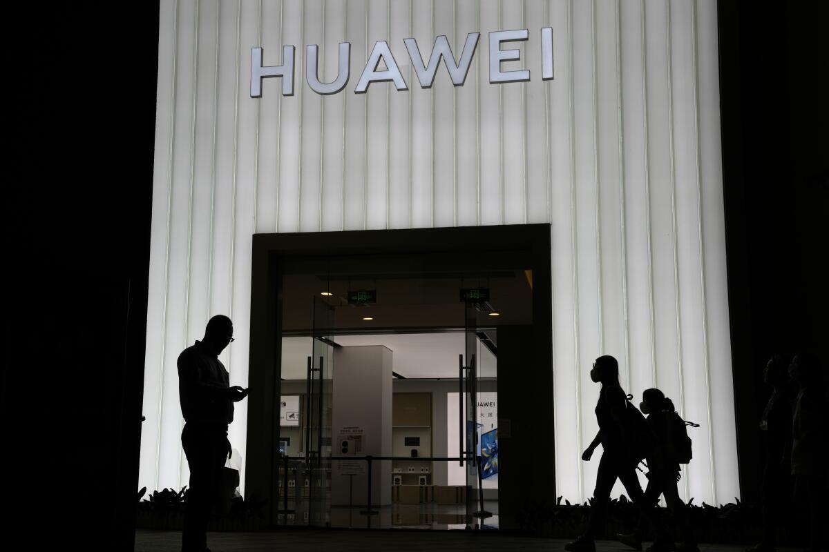 Shoppers pass by a Huawei store in Beijing, China.